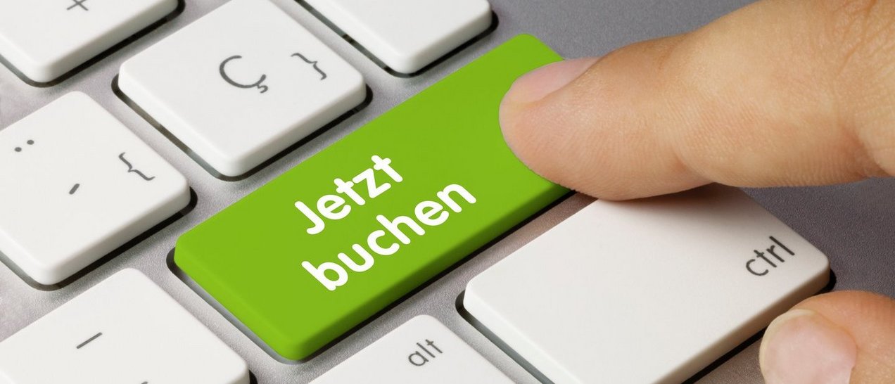 Tastatur mit Finger, der auf "Jetzt buchen" drückt