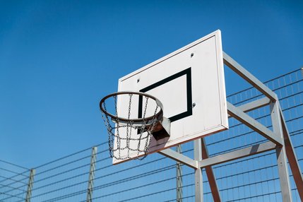 weißes Schild mit schwarzen Rahmen und Basketballkorb an Gestell