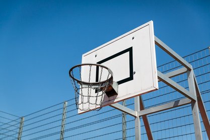 weißes Schild mit schwarzen Rahmen und Basketballkorb an Gestell