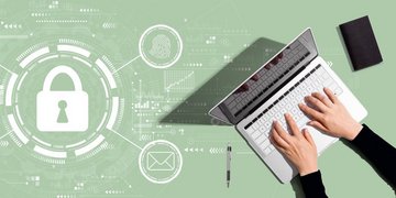 Sicherheitssymbole umschwirren einen Menschen am Notebook